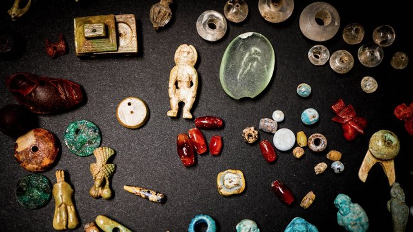 Amulette, Edelsteine, Puppen aus der Truhe.