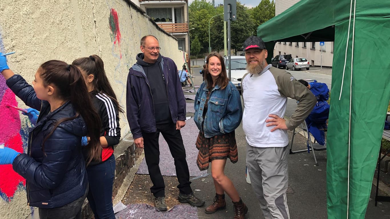 Initiator Stephan Peddinghaus (Grüner Stern Wehringhausen), die Künstlerin Jessica Glomb und der Kurator Dietmar Schneider (Kooperative K) an der Mauer in Wehringhausen, die bald in vielen Farben erstrahlen soll.