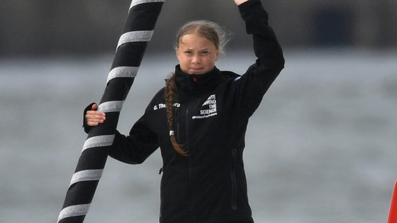 Greta Thunberg winkt von Bord der Hochseejacht "Malizia".