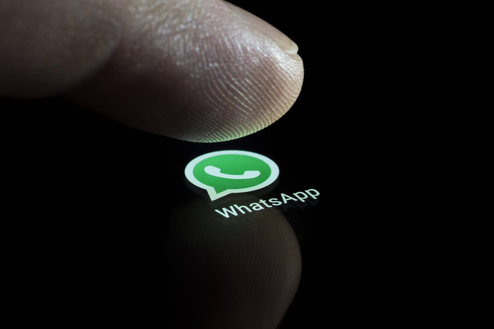 Das Bild zeigt einen Finger, der auf das WhatsApp-Icon tippt: Der Messenger könnte bald eine neue Funktion erhalten.