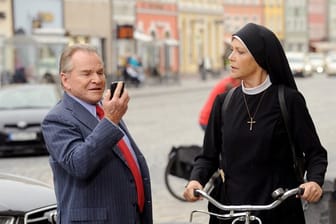 Schwester Hanna (Janina Hartwig) fährt Bürgermeister Wöller (Fritz Wepper) fast mit dem Fahrrad um.
