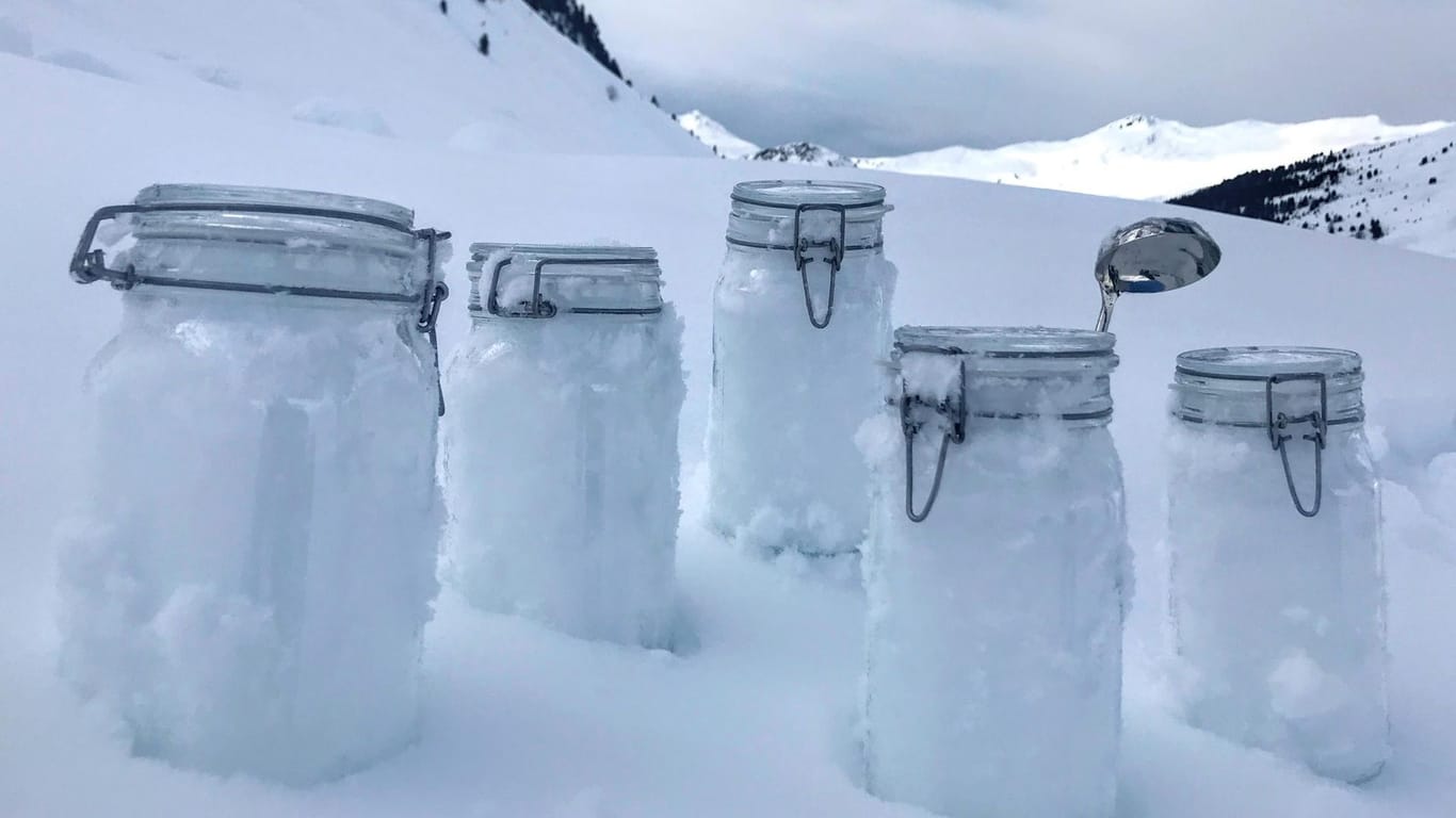 In den Schweizer Bergen stehen Schneeproben auf den Boben.