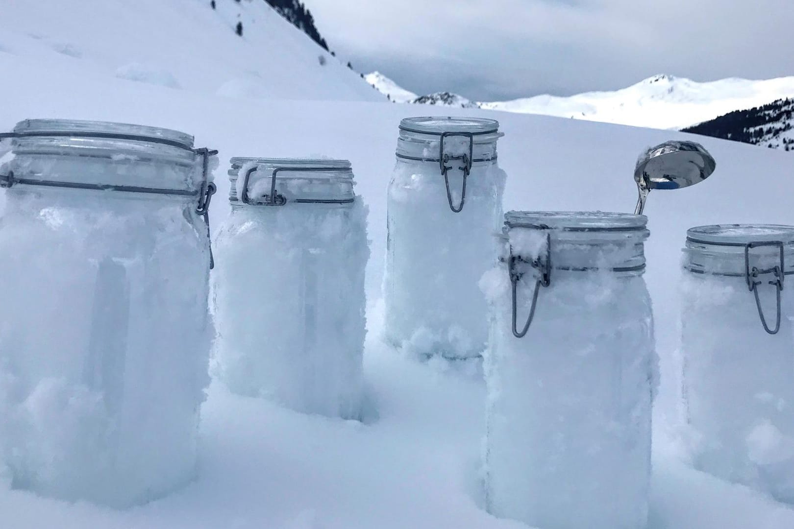 In den Schweizer Bergen stehen Schneeproben auf den Boben.