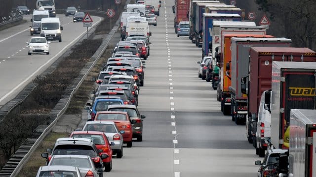 Fahrer von Pkw und Lkw bilden auf einer Autobahn eine Rettungsgasse.