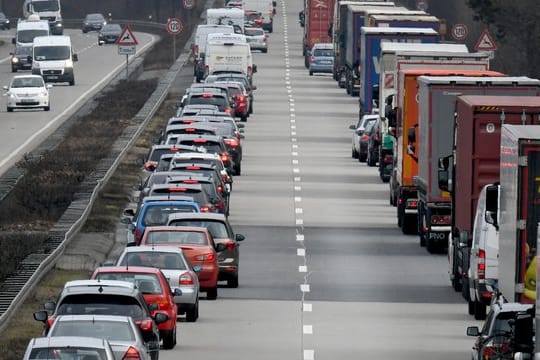 Fahrer von Pkw und Lkw bilden auf einer Autobahn eine Rettungsgasse.