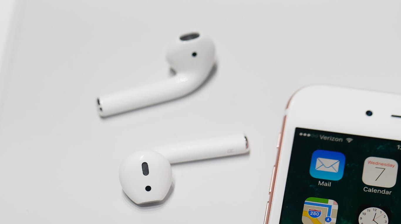 Die AirPods von Apple neben einem iPhone: Die kabellosen Kopfhörer sind heute günstig im Angebot.