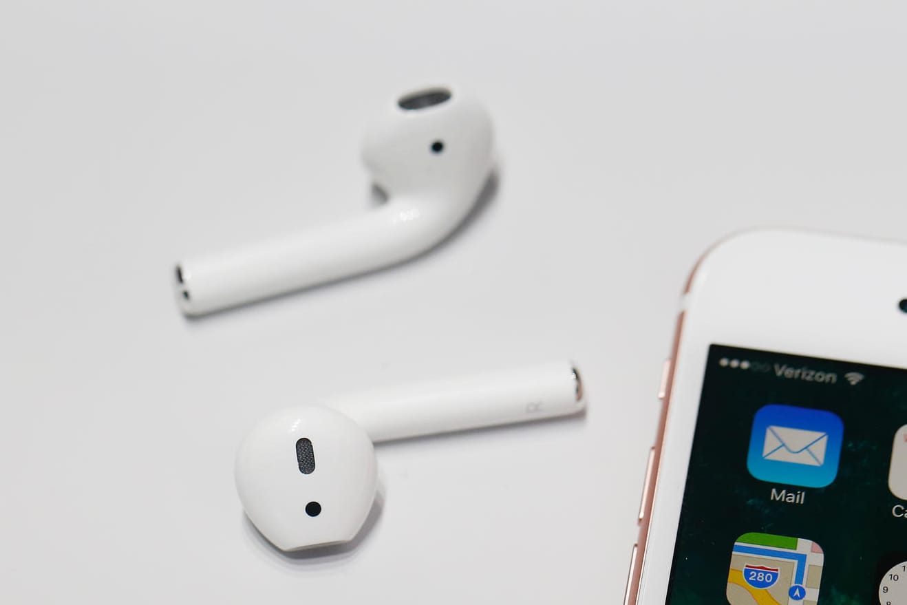 Die AirPods von Apple neben einem iPhone: Die kabellosen Kopfhörer sind heute günstig im Angebot.