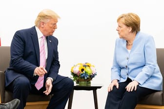 Trump und Merkel beim G20-Gipfel in Osaka: Im Juni trafen die Chefs der 20 wichtigsten Industrie- und Schwellenländer sich in Japan. Die Stimmung zwischen dem US-Präsidenten und der Kanzlerin schwankte. Erst gab es Küsschen, dann grimmige Blicke.