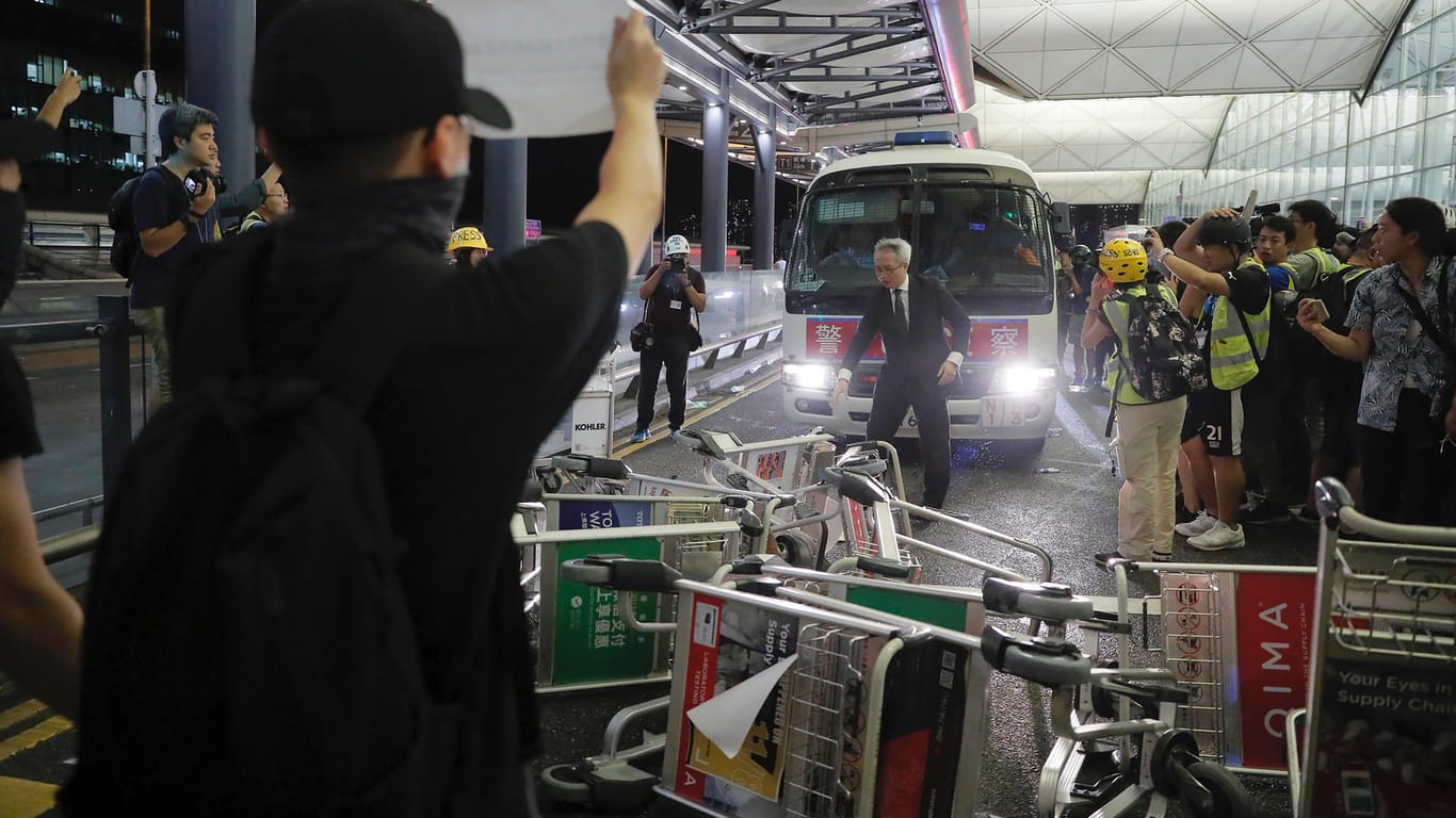 Hong Kong: Demonstranten stellen sich am Flughafen von Hongkong einem Polizeiwagen in den Weg.