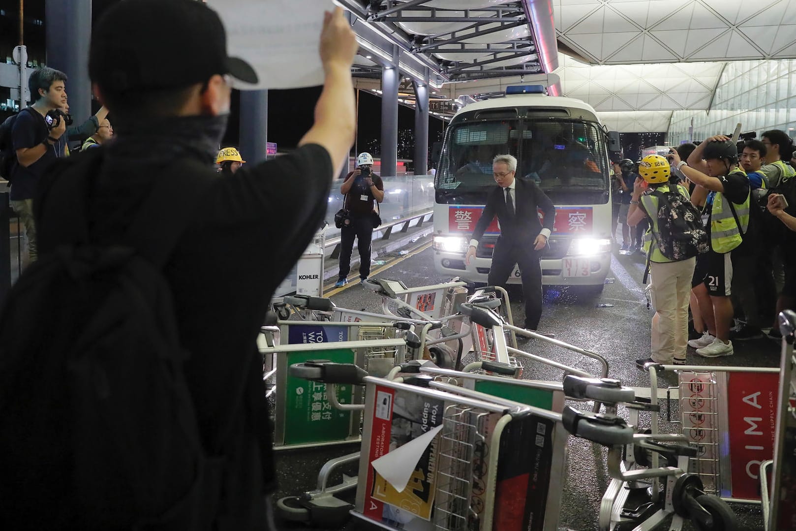 Hong Kong: Demonstranten stellen sich am Flughafen von Hongkong einem Polizeiwagen in den Weg.