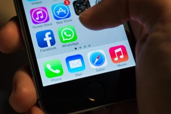 Ein Nutzer öffnet WhatsApp auf einem iPhone: Für Fans der Chat-App gibt es spezielle Mobilfunktarife.