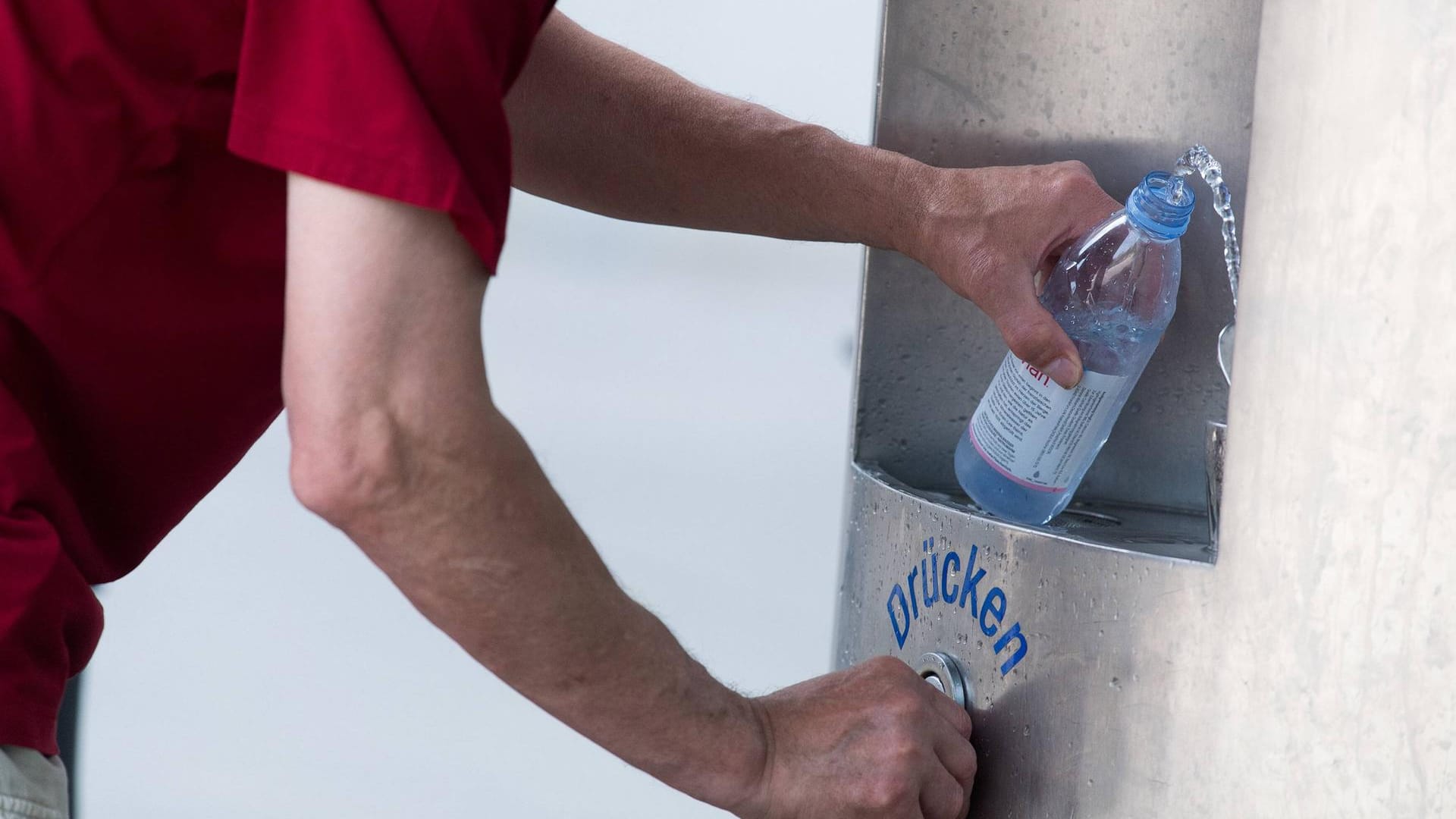 Ein Mann befüllt eine Flasche am Trinkwasserbrunnen: Zwölf neue Brunnen sollen ab Herbst auch in Köln aufgestellt werden.