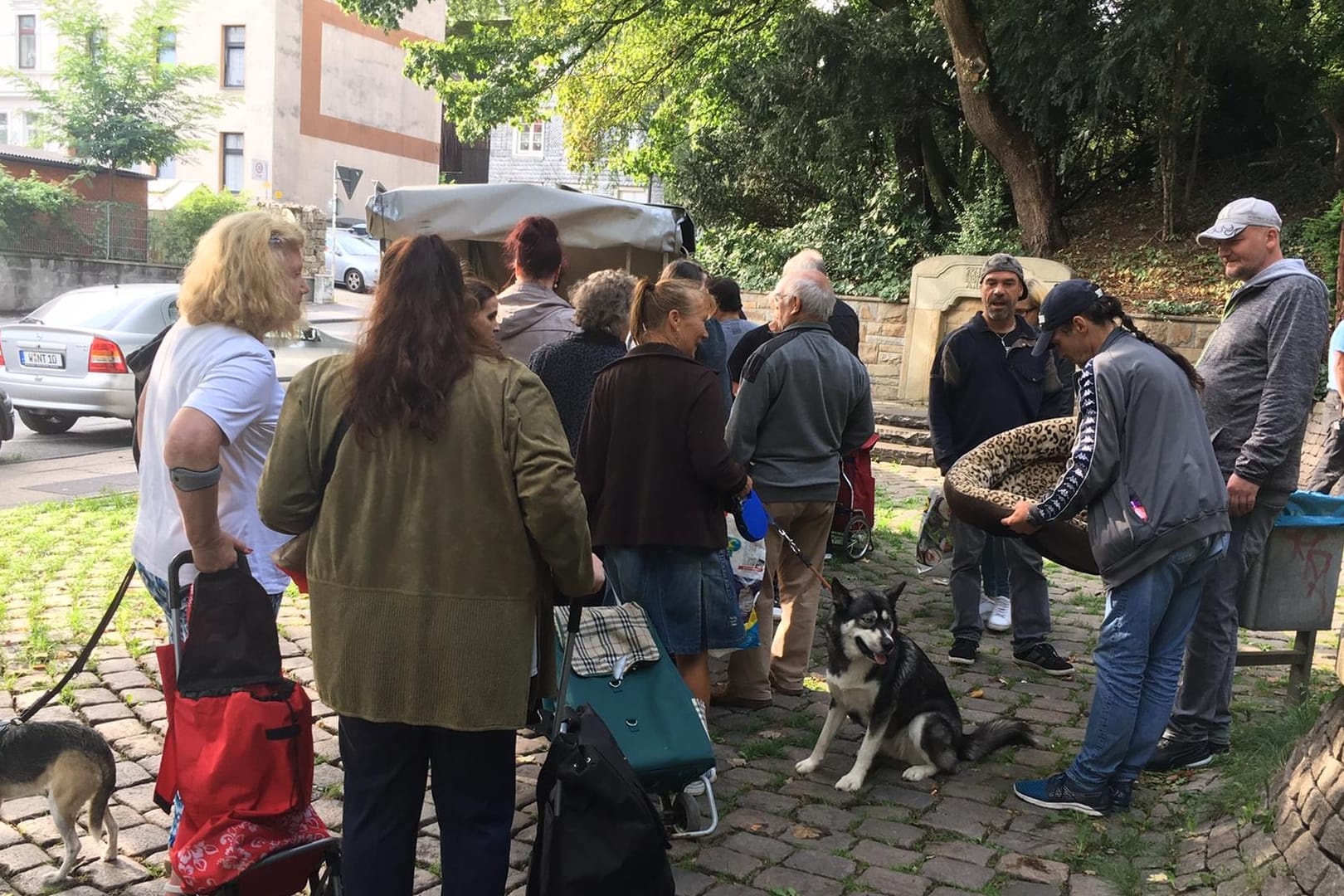 Eine Schlange bildet sich vor einem Anhänger in Wuppertal: Dort stehen Bedürftige bei der mobilen Tiertafel an, um Futter für ihre Tiere abzuholen.