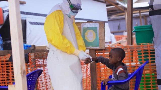 Ein Pfleger versorgt ein Kind, bei dem Verdacht auf Ebola besteht. Ein Pfleger versorgt ein Kind, bei dem Verdacht auf Ebola besteht.