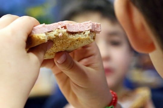 Kinder frühstücken in einer Grundschule.