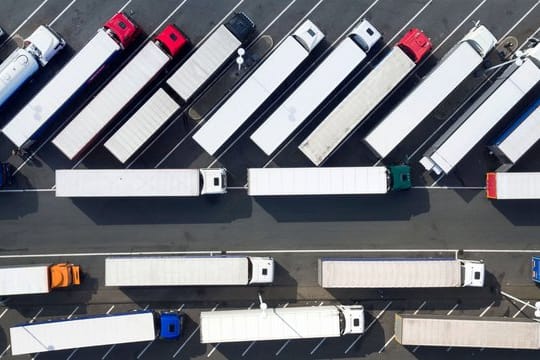 Blick aus der Luft auf abgestellte Lastwagen auf einer Rastätte.