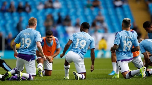 Kevin de Bruyne (l-r), Raheem Sterling und Nicolas Otamendi tragen das Trikot des verletzten Leroy Sané. Kevin de Bruyne (l-r), Raheem Sterling und Nicolas Otamendi tragen das Trikot des verletzten Leroy Sané.