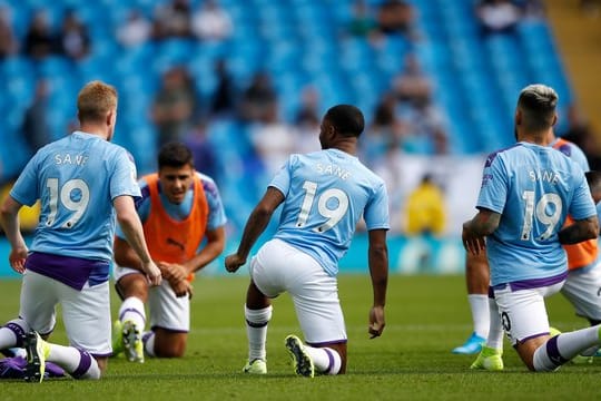 Kevin de Bruyne (l-r), Raheem Sterling und Nicolas Otamendi tragen das Trikot des verletzten Leroy Sané.