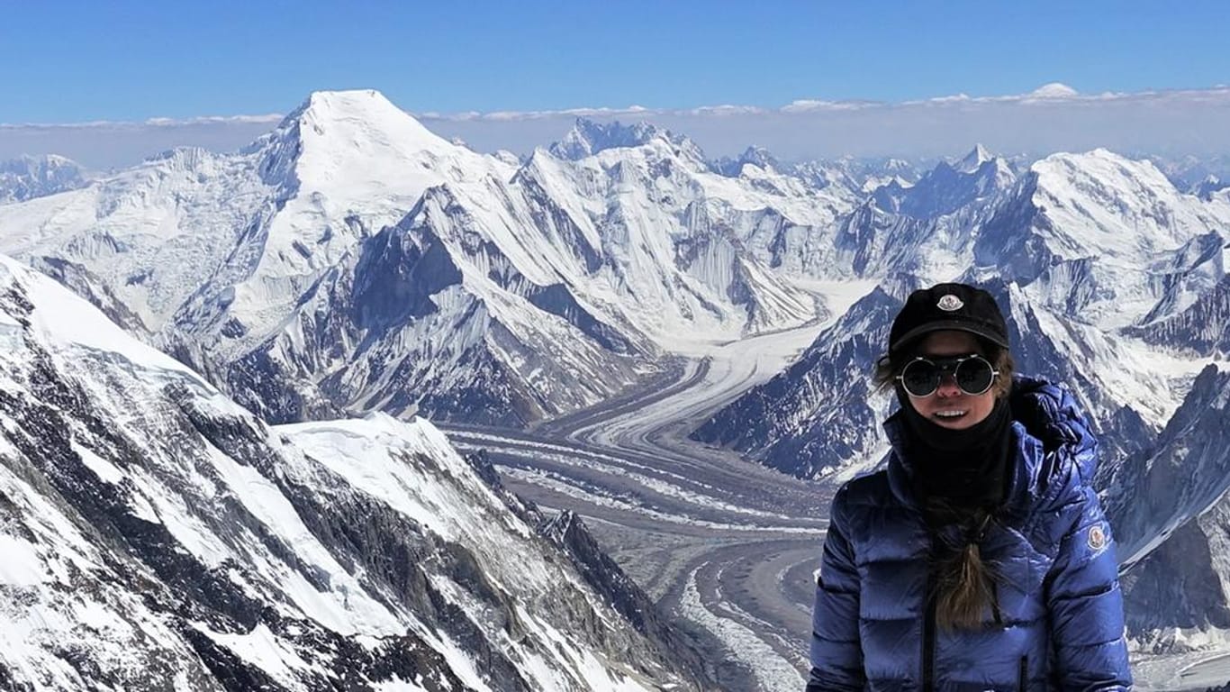 Pakistan, K2: Anja Blacha steht beim Gipfelanstieg zum K2 vor der Kulisse des Broad Peak (l).