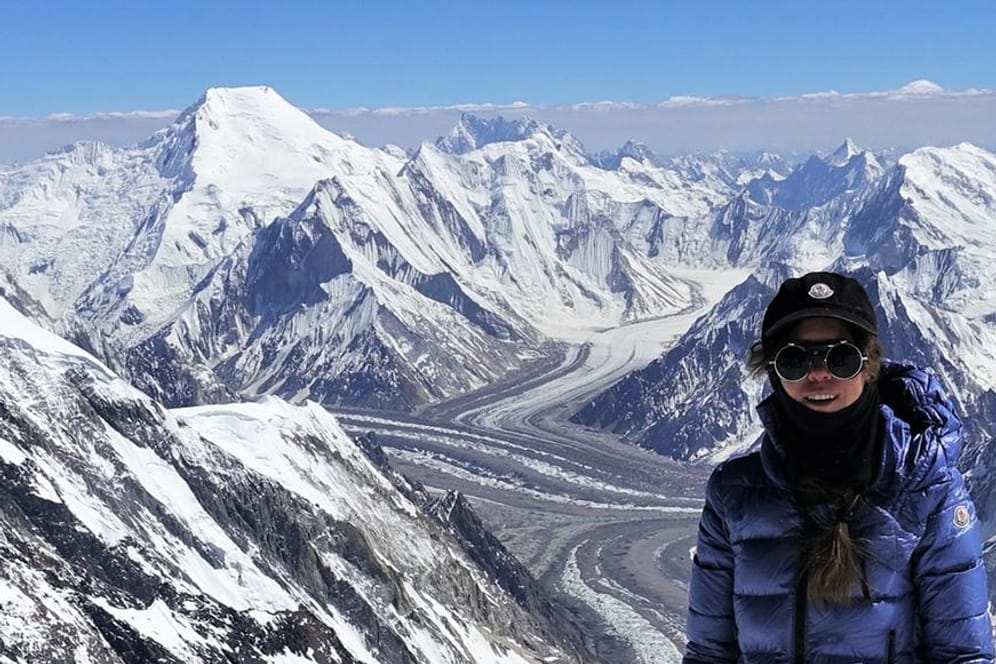Pakistan, K2: Anja Blacha steht beim Gipfelanstieg zum K2 vor der Kulisse des Broad Peak (l).