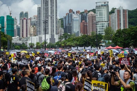 Teilnehmer einer Demonstration kommen zur Protestkundgebung im Victoria Park.
