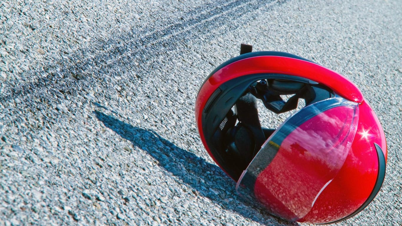 Ein Motorradhelm liegt nach einem Unfall auf der Straße: Der Fahrer verstarb noch am Unfallort. (Symbolbild)