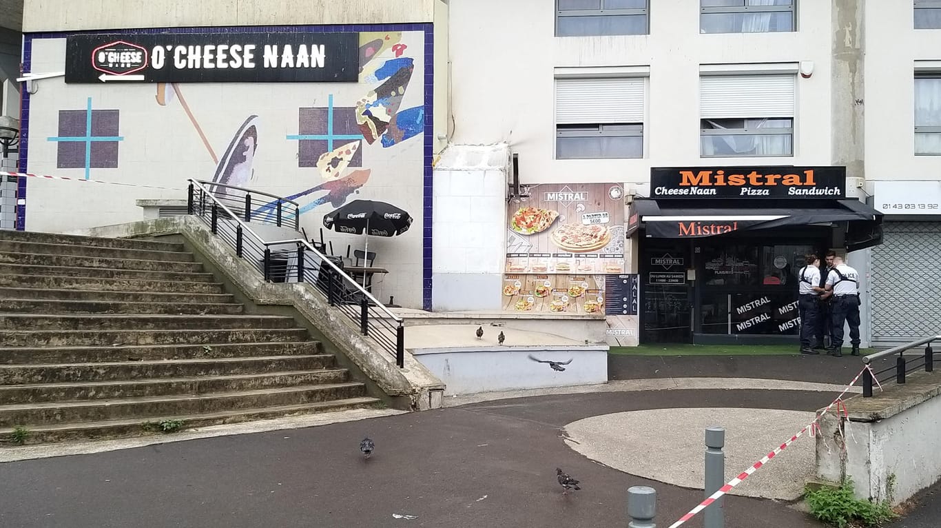 Polizisten stehen vor einem Schnellrestaurant in einem Vorort von Paris, in dem ein Kunde einen Angestellten erschossen haben soll.