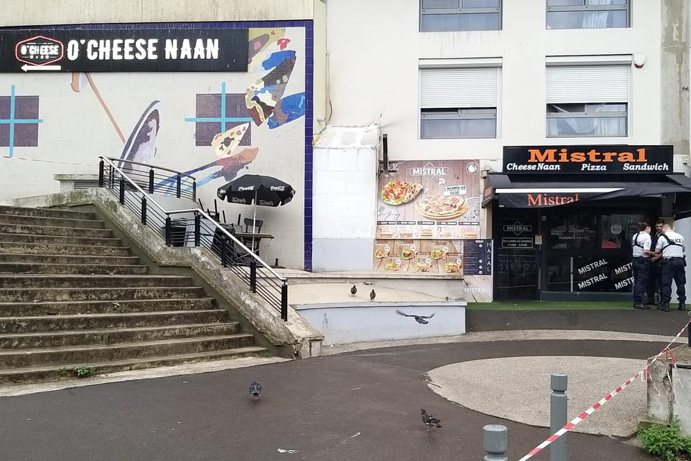 Polizisten stehen vor einem Schnellrestaurant in einem Vorort von Paris, in dem ein Kunde einen Angestellten erschossen haben soll.