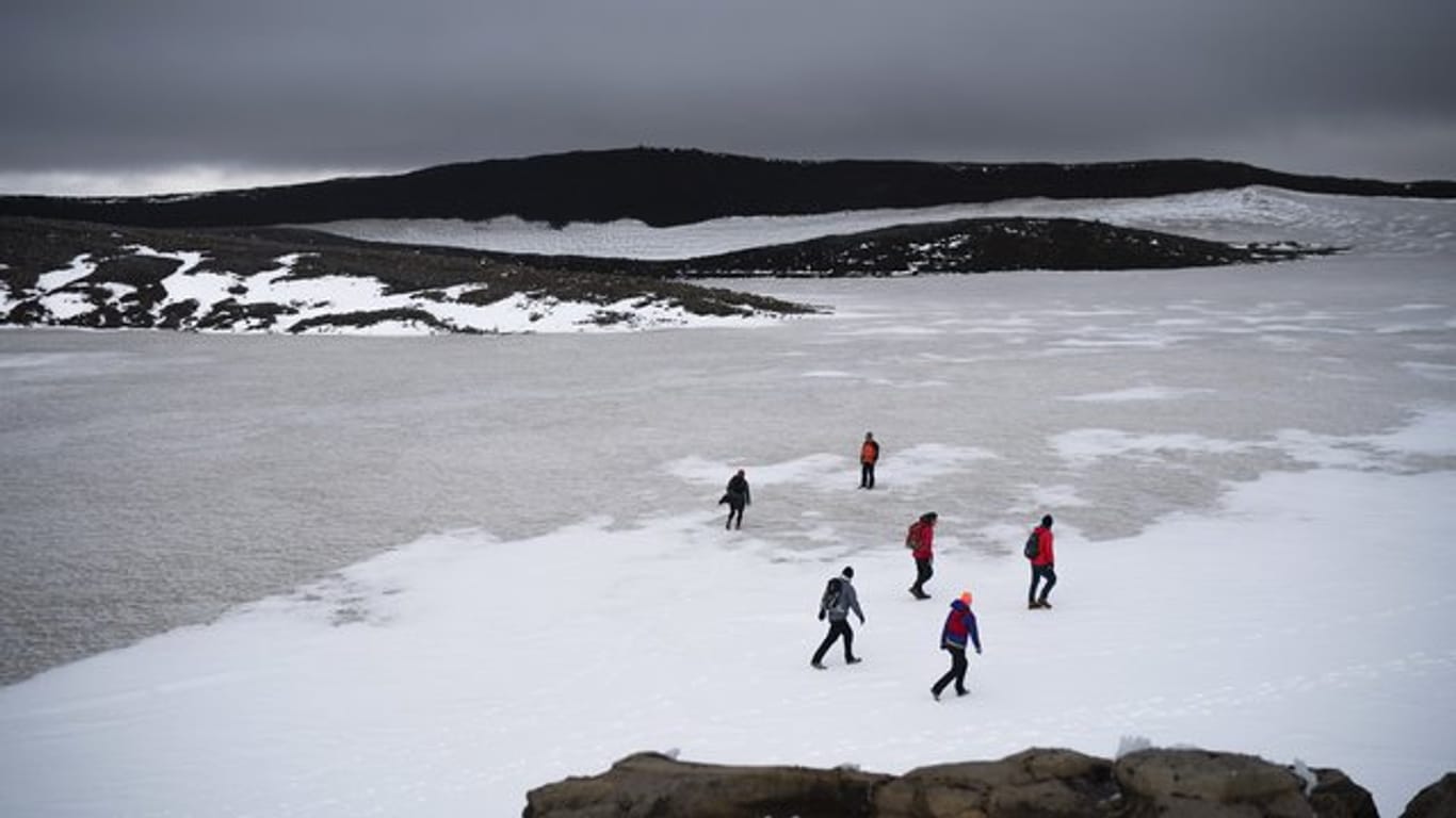 Zahlreiche Menschen wandern über die Reste des Okjökull zu einer Gedenkveranstaltung für den vergangenen Gletscher.