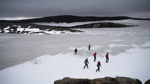 Zahlreiche Menschen wandern über die Reste des Okjökull zu einer Gedenkveranstaltung für den vergangenen Gletscher. Zahlreiche Menschen wandern über die Reste des Okjökull zu einer Gedenkveranstaltung für den vergangenen Gletscher.