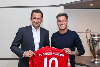 Philippe Coutinho (r) präsentiert mit Bayern-Sportdirektor Hasan Salihamidzic sein neues Trikot.