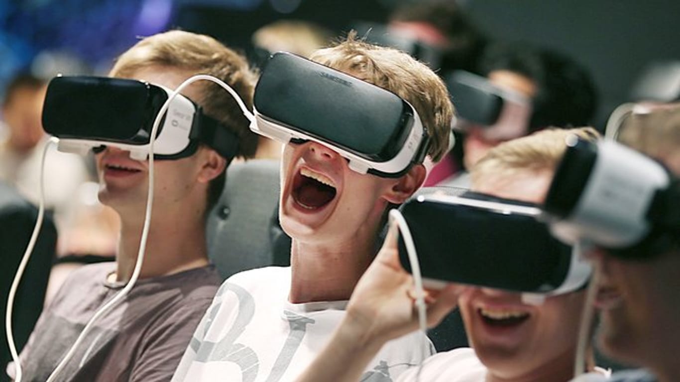 Besucher der Gamescom tauchen mittels VR-Brillen in ein Computerspiel ein.