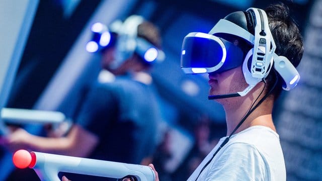 Ein Besucher der Gamescom 2018 probiert an einem Stand ein Videospiel mit einer VR-Brille aus. Ein Besucher der Gamescom 2018 probiert an einem Stand ein Videospiel mit einer VR-Brille aus.