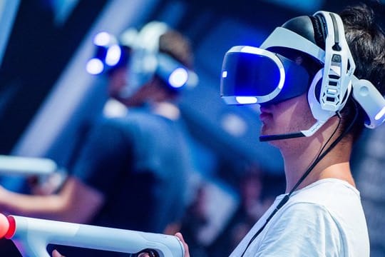 Ein Besucher der Gamescom 2018 probiert an einem Stand ein Videospiel mit einer VR-Brille aus.