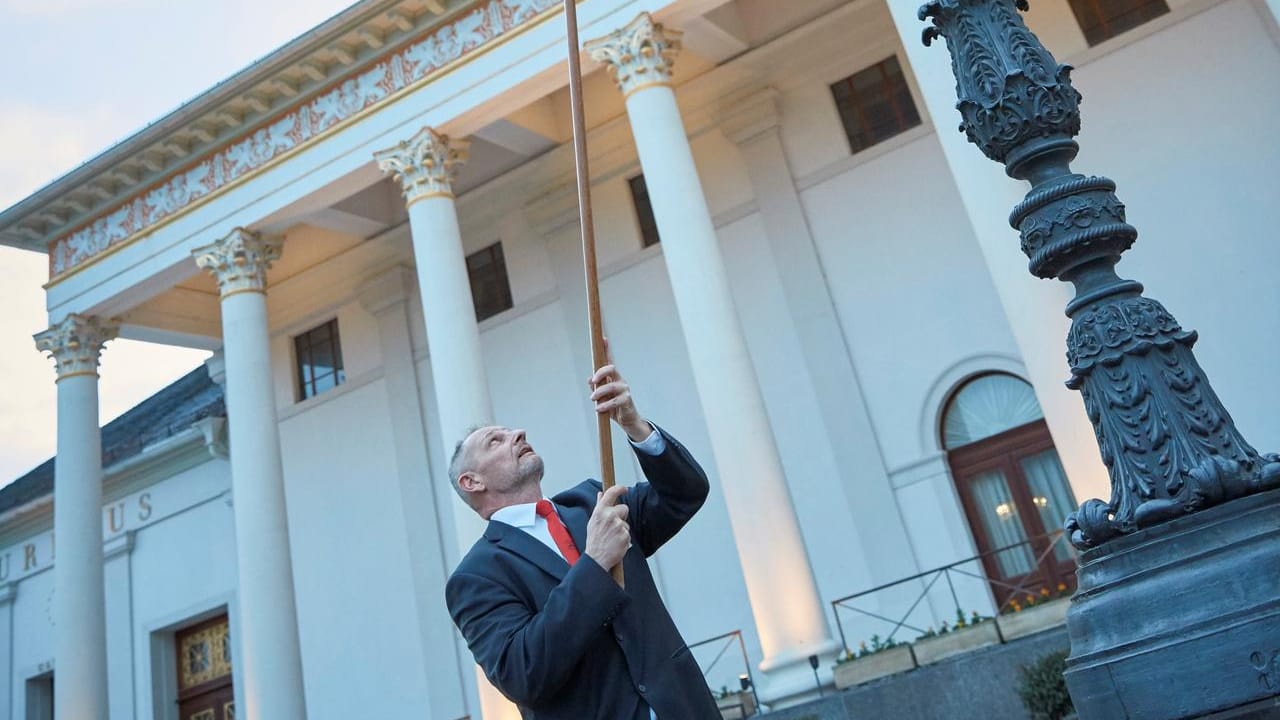 Klaus Peter zündet eine Lampe in Baden-Baden an: Der Lampenanzüder entzündet jeden Abend per Hand vor dem Kurhaus die Kadelaber.