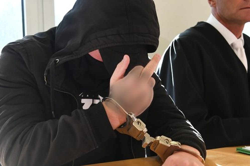 Kaltschnäuzig: Der 19-jährige Angeklagte zeigt im Landgericht in Stralsund den Mittelfinger.
