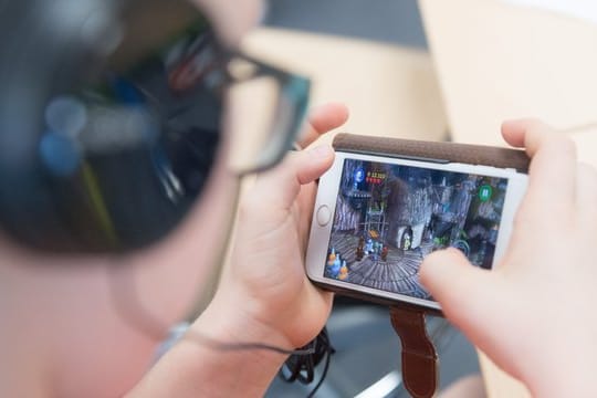 Ein Schüler spielt auf einem Smartphone ein Videospiel.