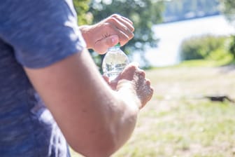 Mann mit Wasserflasche: Auf Reisen ist es sinnvoll, abgefülltes Wasser zu trinken. Wer in manchen Ländern Leitungswasser trinkt, riskiert Durchfallerkrankungen.