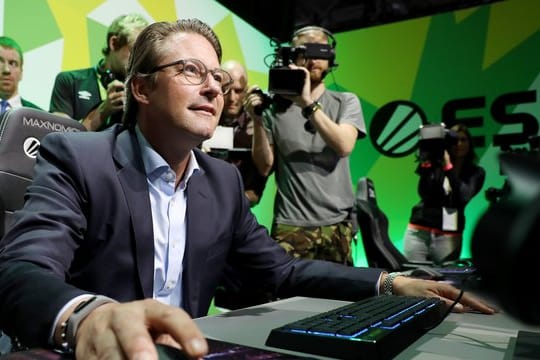 Andreas Scheuer, Bundesminister für Verkehr und digitale Infrastruktur, sitzt auf der Gamescom an einem Computerspiel.