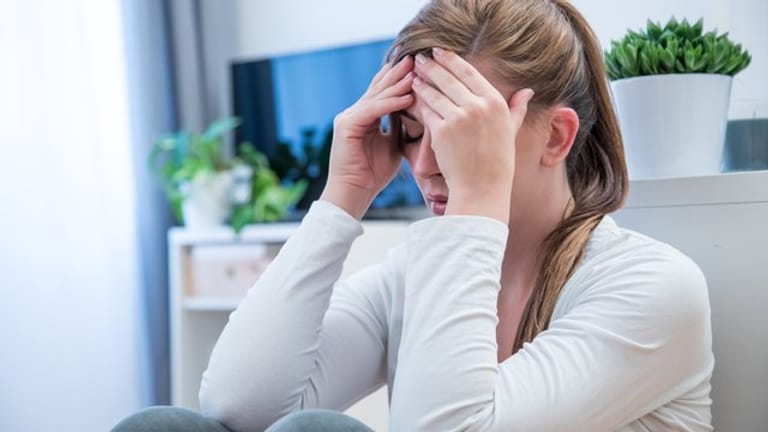 Frau mit Kopfschmerzen: Spannungskopfschmerzen und Migräne gehören zu den zwei häufigsten Arten von Kopfschmerzen.
