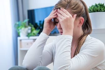 Frau mit Kopfschmerzen: Spannungskopfschmerzen und Migräne gehören zu den zwei häufigsten Arten von Kopfschmerzen.