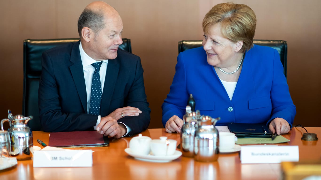 Olaf Scholz (SPD) und Angela Merkel (CDU): Für die meisten Bundesbürger fällt der Soli weg.