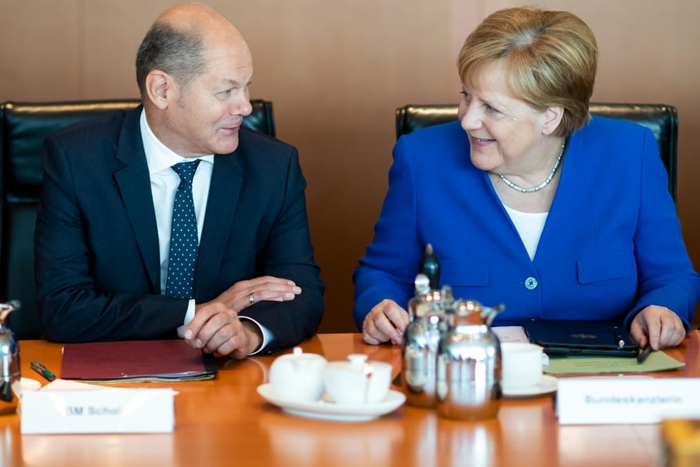 Olaf Scholz (SPD) und Angela Merkel (CDU): Für die meisten Bundesbürger fällt der Soli weg.