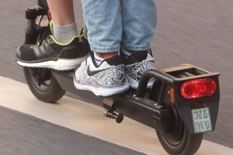 Zwei Männer fahren auf einem E-Scooter: Gegen diesen und weitere Verstöße will die Mainzer Polizei nun verstärkt vorgehen.