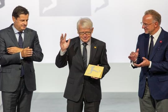 Reinhard Rauball (M) wird durch Christian Seifert (l) und Karl-Heinz Rummenigge verabschiedet.