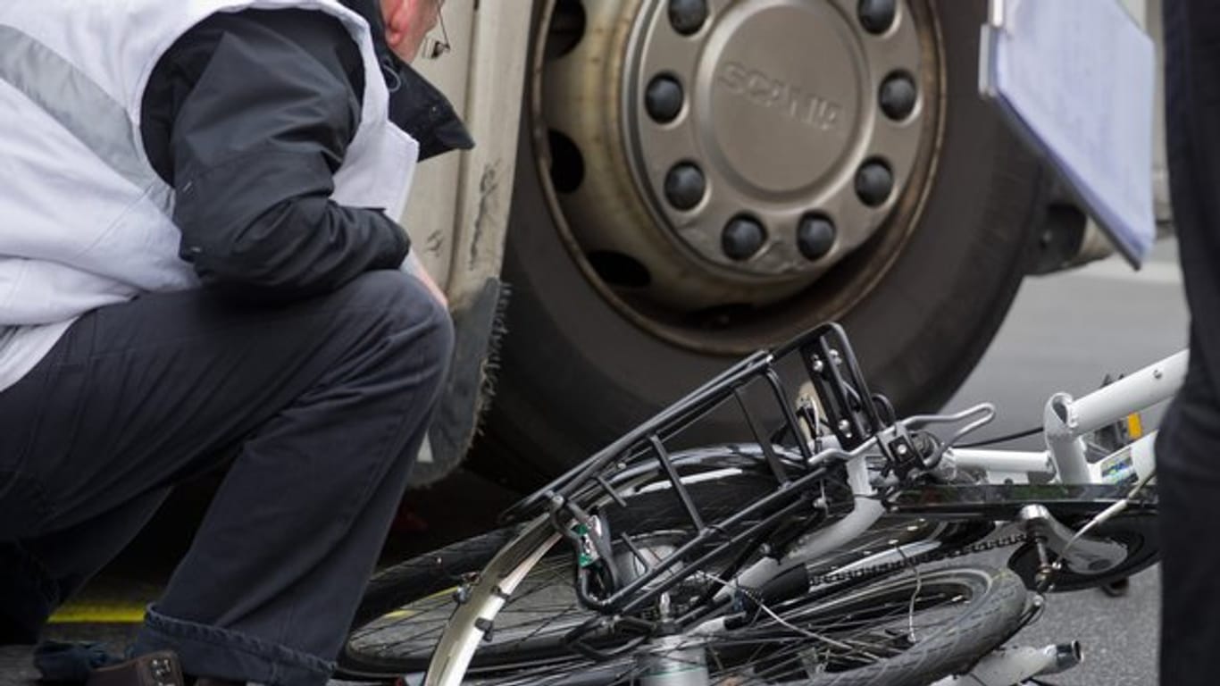 Unter dem Lkw: Polizisten und Gutachter bergen in Berlin ein völlig zertrümmertes Fahrrad.