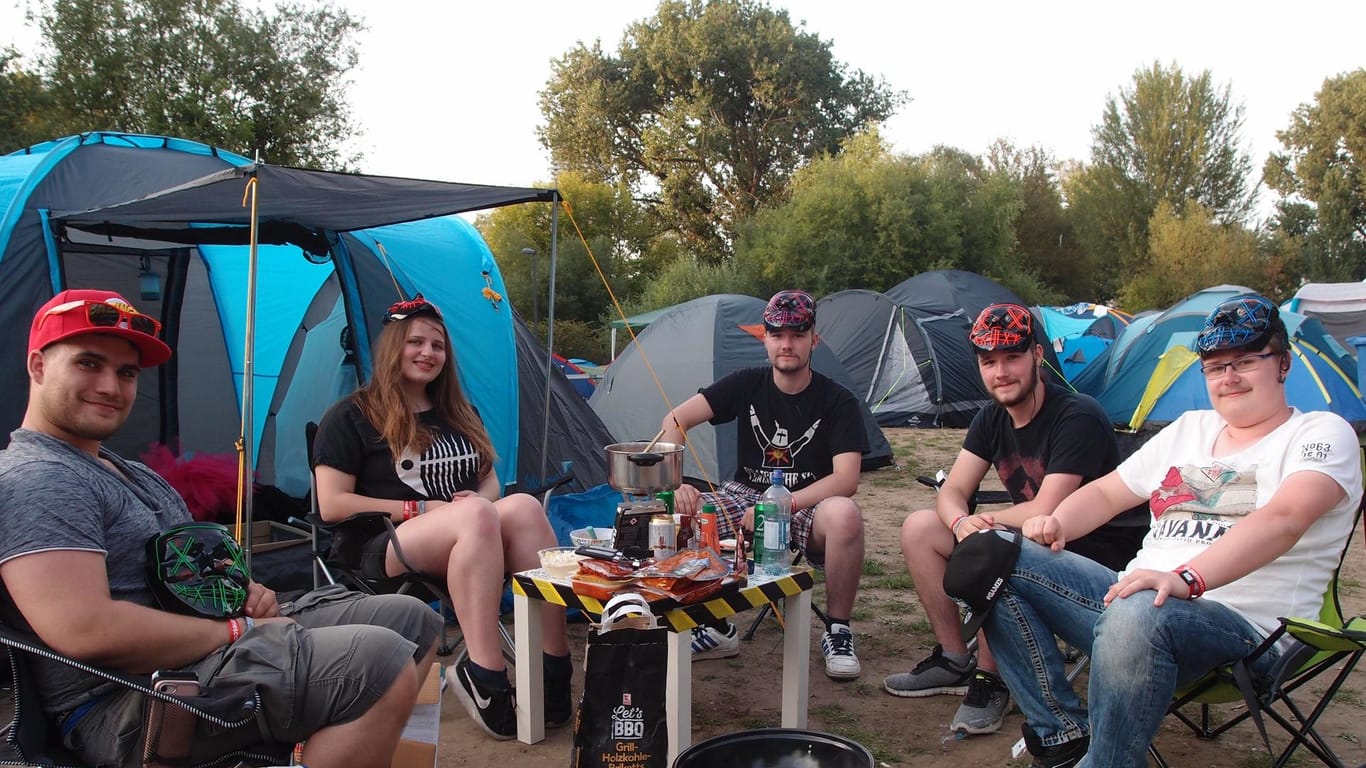 Freunde sitzen um einen Grill herum: Die Truppe ist zum ersten Mal im Gamescom-Camp und ist von der Stimmung begeistert.