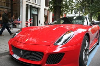 Ein Ferrari parkt auf der Königsallee in Düsseldorf, die als Laufsteg der Reichen und Schönen gilt.