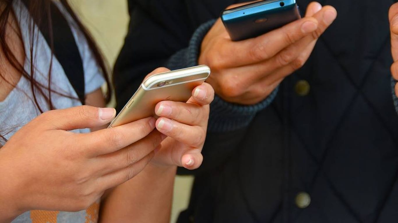 Eine Frau und ein Mann nutzen ihr Smartphone: Bei Prepaid-Tarifen variiert der Abrechnungszeitraum. Darauf sollten Verbraucher beim Preisvergleich Rücksicht nehmen.
