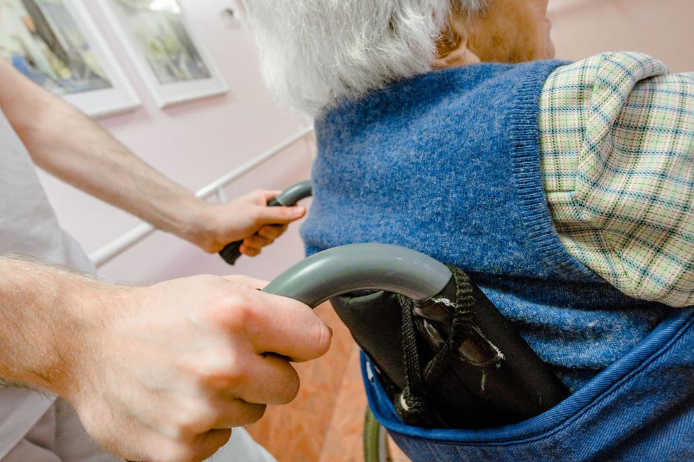Pfleger schiebt Senioren in einem Rollstuhl: Die Kommunikation in einem Heim sollte von Respekt geprägt sein.
